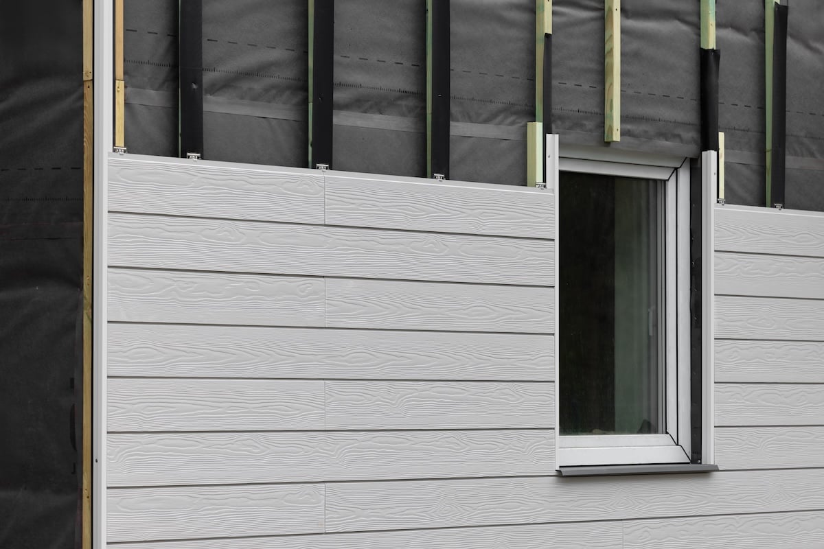 wood texture composite cladding installation on house facade. WPC exterior wall panels