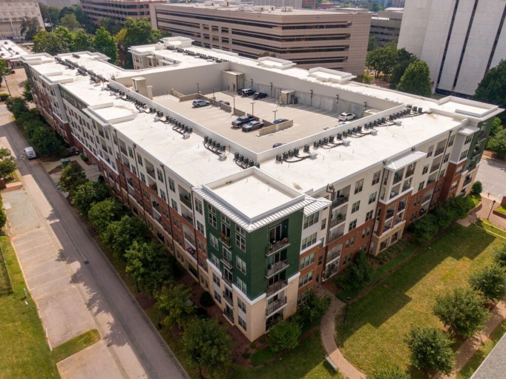 Daytime Drone Images Of An Apartment Building With Multiple Hvac Systems And A Parking Lot