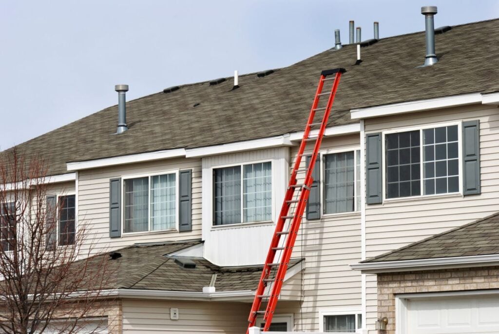 Ladder Extending To Apartment Roof For Repairs. Multi Family Roof Repair
