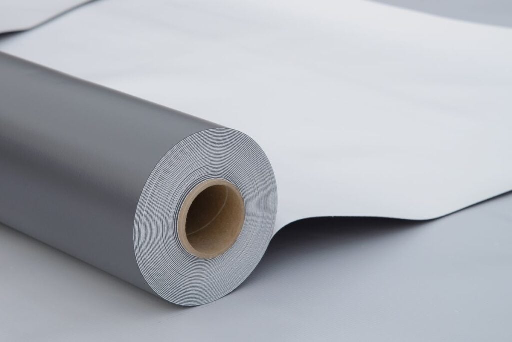 Waterproofing And Insulation At Construction Site, Opened Pvc Membrane Roll Lying On Roof Closeup